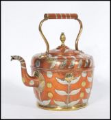 An early 20th century copper kettle teapot having silver overlay leaf decoration with brass flower