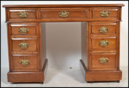 An Edwardian twin mahogany pedestal desk being raised on plinth bases, each pedestal with banks of