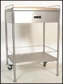 A vintage retro 20th century wooden butchers block raised on a stainless steel cabinet side table