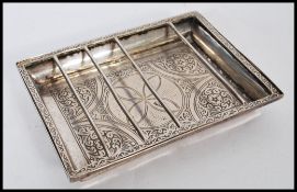 A 19th century Egyptian silver serving dish of square form having floral medallions with barred