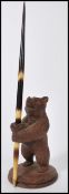 A vintage early 20th century Blackforest carved pen stand in the form of a bear raised on circular
