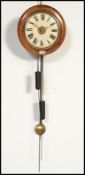 A Victorian mahogany and brass postmans clock. The circular dial with roman numeral chapter ring