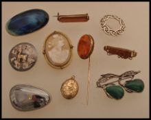 A blue and green ceramic brooch stamped Ruskin to the back, along with a selection of other brooches