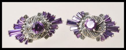 A pair of silver dress earrings set with amethysts and marcasite accent stones. Weight 12.7g.