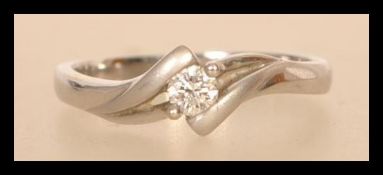 An 18ct white gold crossover diamond ring having a central diamond of approx 15pts. Weighs 3.7