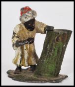 An early 20th century cold painted bronze miniature of an Arab man resting by a tree trunk. Measures