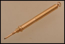 A hallmarked early 20th century 15ct gold propelling pen being contained within a pendant. Weighs