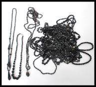 A large collection of vintage costume jewellery black glass necklaces in a wide range of lengths
