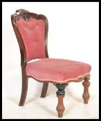A Victorian 19th century mahogany nursing chair being raised on reeded and turned legs with