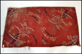 A hand woven Chinese / Tibetan rectangular floor rug having red ground  with decorative sprays of