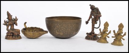 A pair of 20th century Nepalese cast metal figures of nude deities raised on pedestal bases along