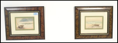 A pair of framed and glazed watercolour paintings of rowing boats on shore signed by artist Gamrit