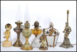 A collection of vintage lighting to include three oil lamps, two vintage cherub lamps, fish lamp,