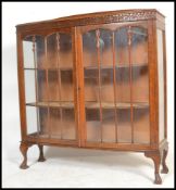 A 1920's oak glass fronted Queen Anne China display cabinet bookcase. Raised on Queen Anne
