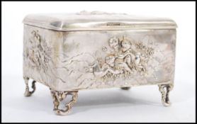 An early 20th century hallmarked silver jewellery casket box raised on scrolled feet having relief