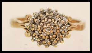 A hallmarked 9ct gold cluster ring having a round head set with a cluster of white stones, having
