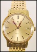 A vintage 1970's Omega Automatic Geneve watch having a gilt dial with baton numerals and date