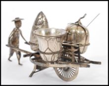 A 20th Century Chinese silver cruet set in the form of a man pushing a wheel barrow having three