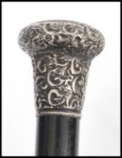 A 19th century Victorian walking stick cane having a tapering ebony shaft with scrolled and