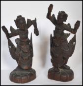 A pair of early 20th century Chinese / Asiatic wooden hand carved figurines of Buddhas / deities