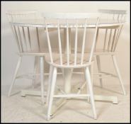 A retro 20th Century circular dining table raised on a single pedestal on a quadruped base