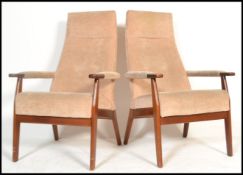 A pair of mid century teak wood high back armchairs of Danish influence having champagne velour