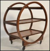 A 1930's Art Deco teak trolley of circular form with multiple tiers having faux coromandel tier