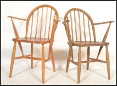 A near pair of Ercol light elm and beech  hoop back carver dining chairs, the chairs with solid seat
