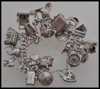 A silver hallmarked charm bracelet together with twenty - five assorted charms to include a boot,