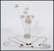 A selection of decorative glass flowers having twisted stems and flowers to the head within a