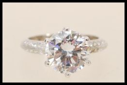 A stamped 925 silver ring set with a large brilliant cut cubic zirconia with accent stones to the