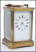An early 20th Century brass bound carriage clock having roman numerals to the chapter ring and