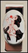 A stamped sterling silver money clip having an enamelled panel to the front depicting a vintage