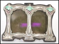A Liberty / Art Nouveau style double picture frame with sterling silver decoration to the front with