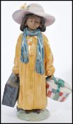 A LLadro ceramic figurine of a girl with luggage model 2388 being stamped to base. 28cm high.