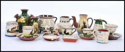 A selection of Torquay Mottoware to include creamer jugs, stem vases, plates condiments etc. All