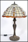A 20th Century twin bulb Tiffany inspired table lamp, the cast base of Art Nouveau taste having a