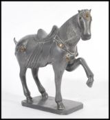 A 20th Century Chinese Tang dynasty style metal war horse figurine on a square base having its front