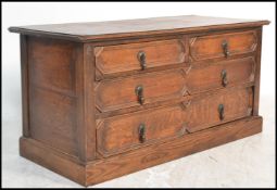 A Jacobean revival geometric fronted low ' end of bed' oak chest of drawers. Raised on a plinth base