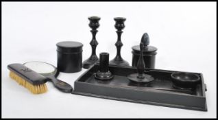 An early 20th Century ebony dressing table set, having a gallery tray, candlesticks, ring stand,
