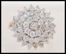 A stamped 375 9ct gold diamond cluster ring having a large round head prong set with brilliant cut
