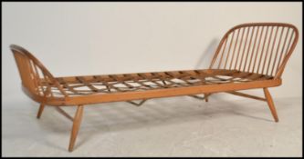 A mid century Ercol blonde beech and elm wood single bed / studio day bed / sofa settee. Raised on