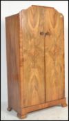 A 1930's Art Deco walnut wardrobe. Shaped feet with twin full length panel doors enclosing a