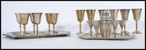 A selection of silverplate items to include a group of small engraved measures with a small cocktail