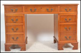 A contemporary mahogany 20th Century twin pedestal desk, having an arrangement of nine drawers