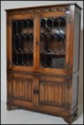 A Jaycee oak china - bookcase display cabinet having leaded glass doors with further cupboard with