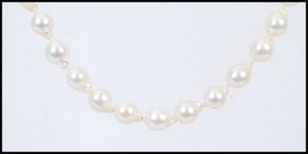 A Baroque pearl necklace with a stamped 375 9ct gold clasp in a Guernsey Pearl box. Measures 18