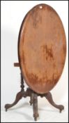 A Victorian mahogany oval breakfast tilt top dining table raised on a pedestal support with tilt