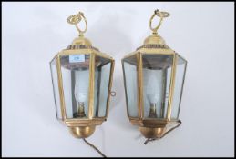 A pair of 20th century brass porch lanterns, each of tapering hexagonal form with clear glass panels
