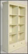 A large contemporary painted bookcase cabinet, possibly Laura Ashley or Multiyork. Raised on